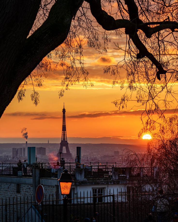 the eiffel tower is silhouetted against an orange and pink sunset in paris