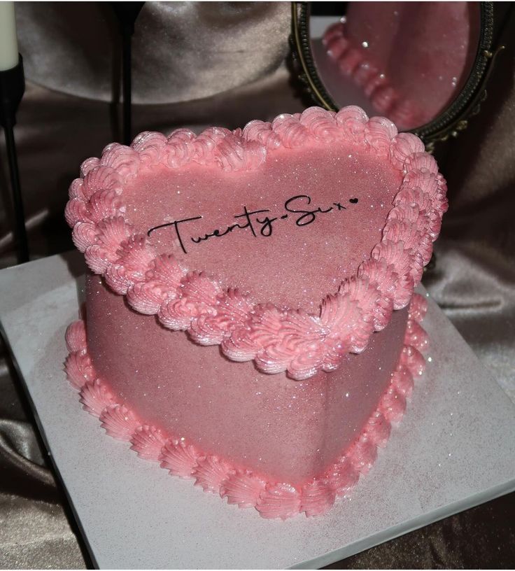 a pink heart shaped cake with the words tunts sr on it's side