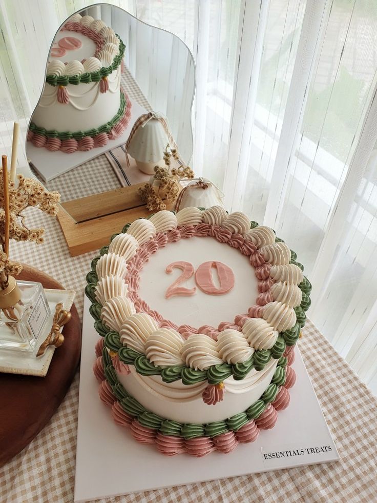 a cake with the number twenty on it sitting on a table next to a mirror