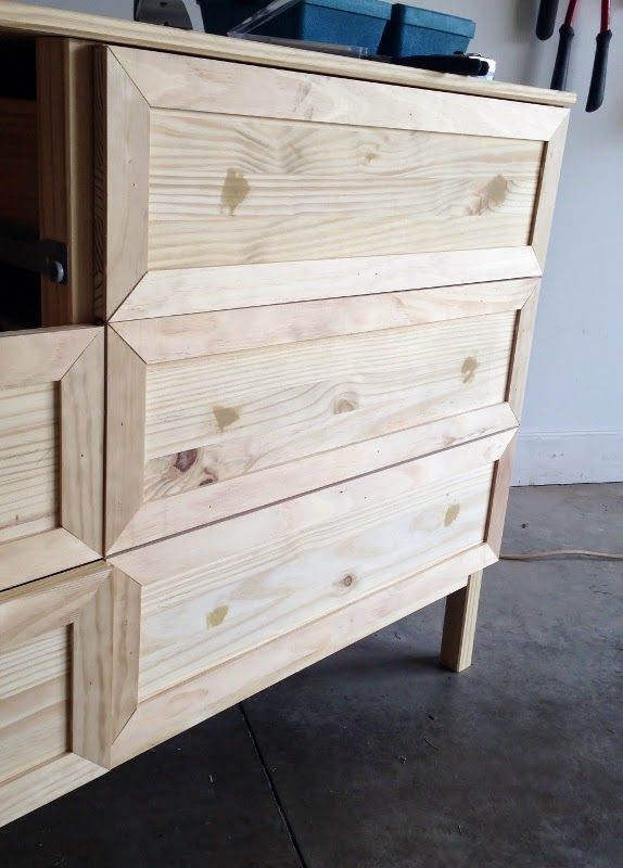 a large wooden dresser sitting on top of a cement floor next to a white wall