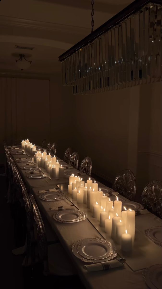 a long table with many lit candles on it