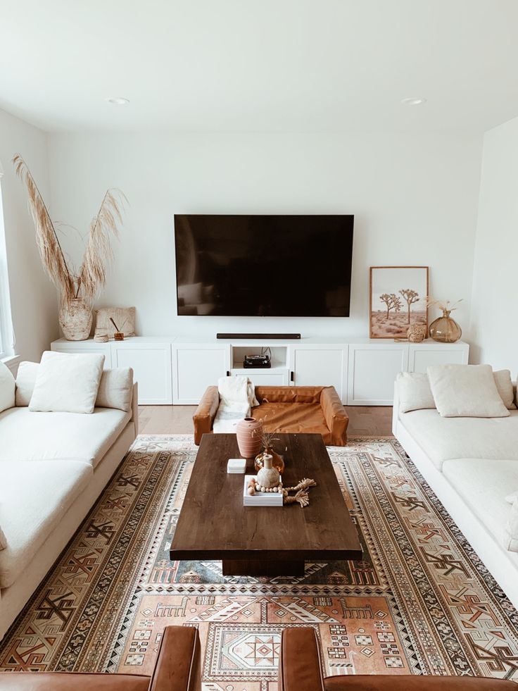 a living room filled with furniture and a flat screen tv mounted to the side of a wall