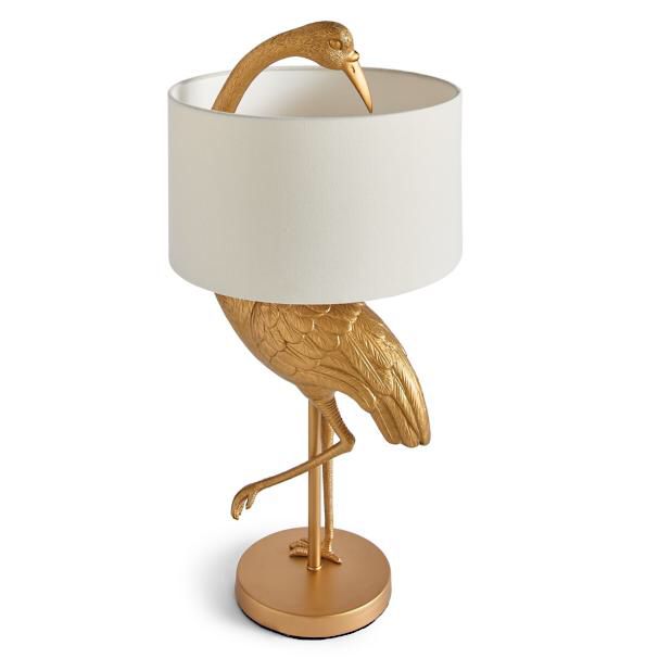 a gold bird lamp with a white shade