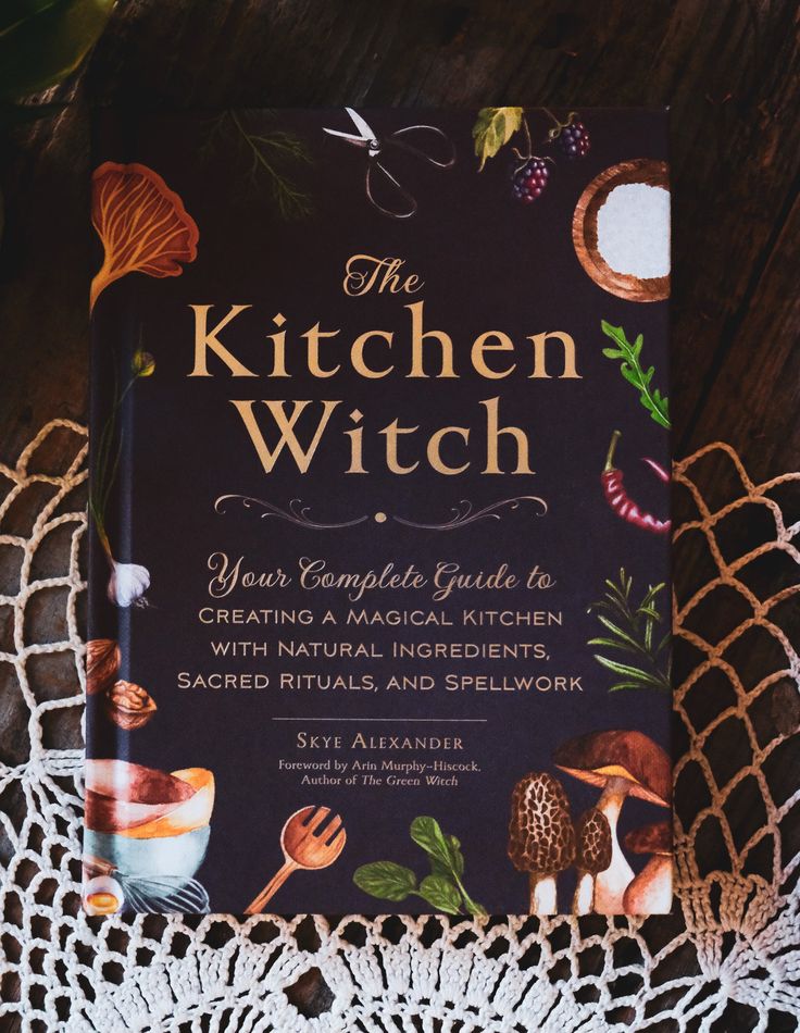 the kitchen witch book sitting on top of a doily