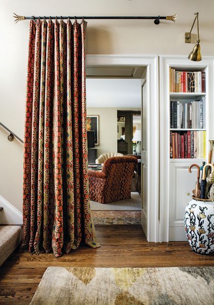 an image of a room with curtains on the door and some bookshelves in the background