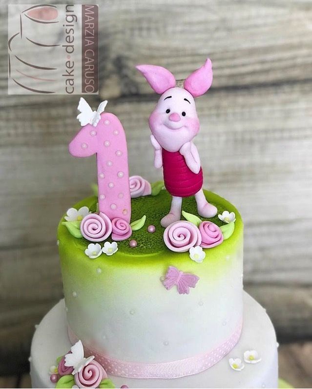 a pink and green birthday cake with a rabbit on it's number one frosting