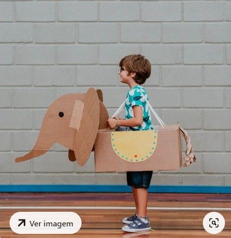 a young boy is holding a cardboard elephant