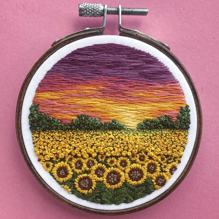 a sunflower field with trees and sunset in the background embroideryed onto an embroidered hoop