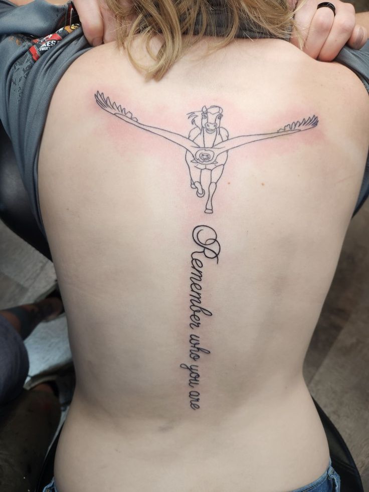 a woman with a cross tattoo on her back