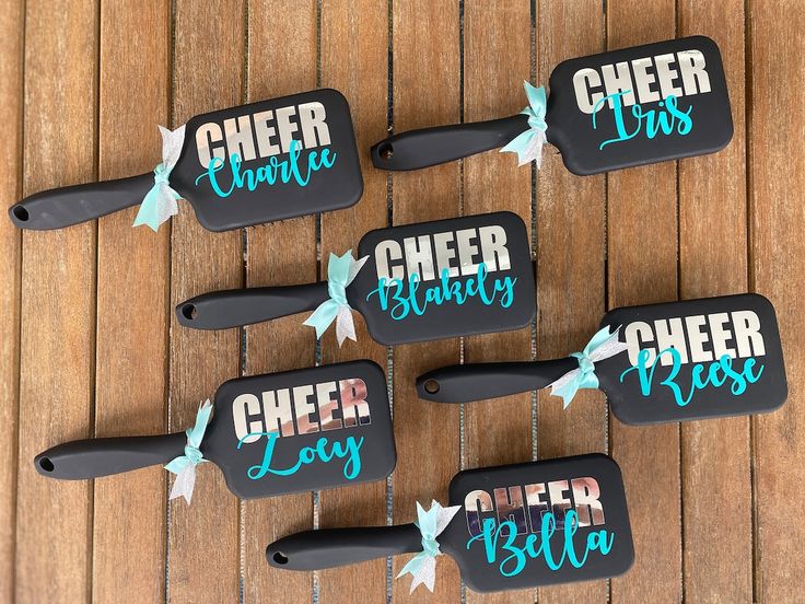 four bottle openers that have been decorated with the words cheer boss and bow on them