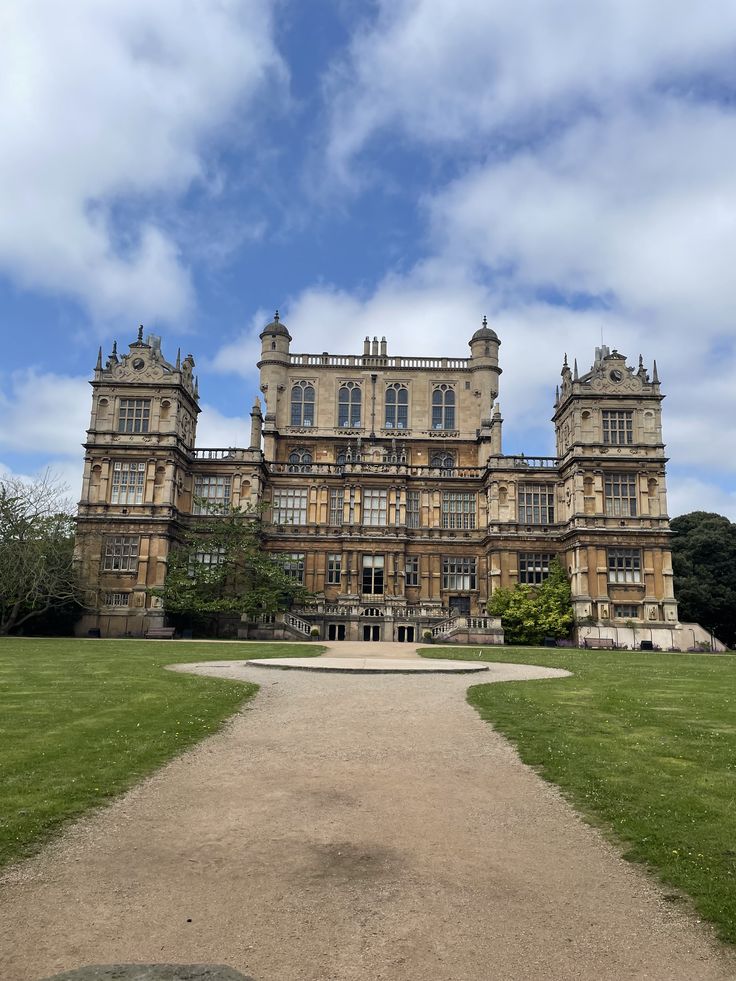 a large building with many windows on the top floor and lots of green grass in front of it