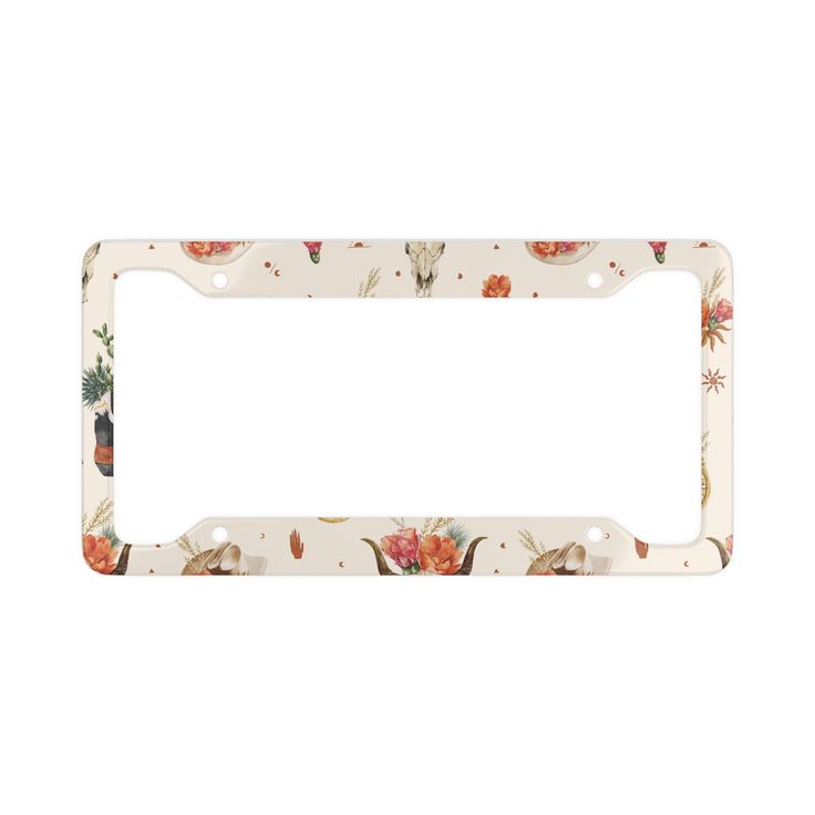 a white license plate frame with flowers and leaves on the bottom, in front of a white background