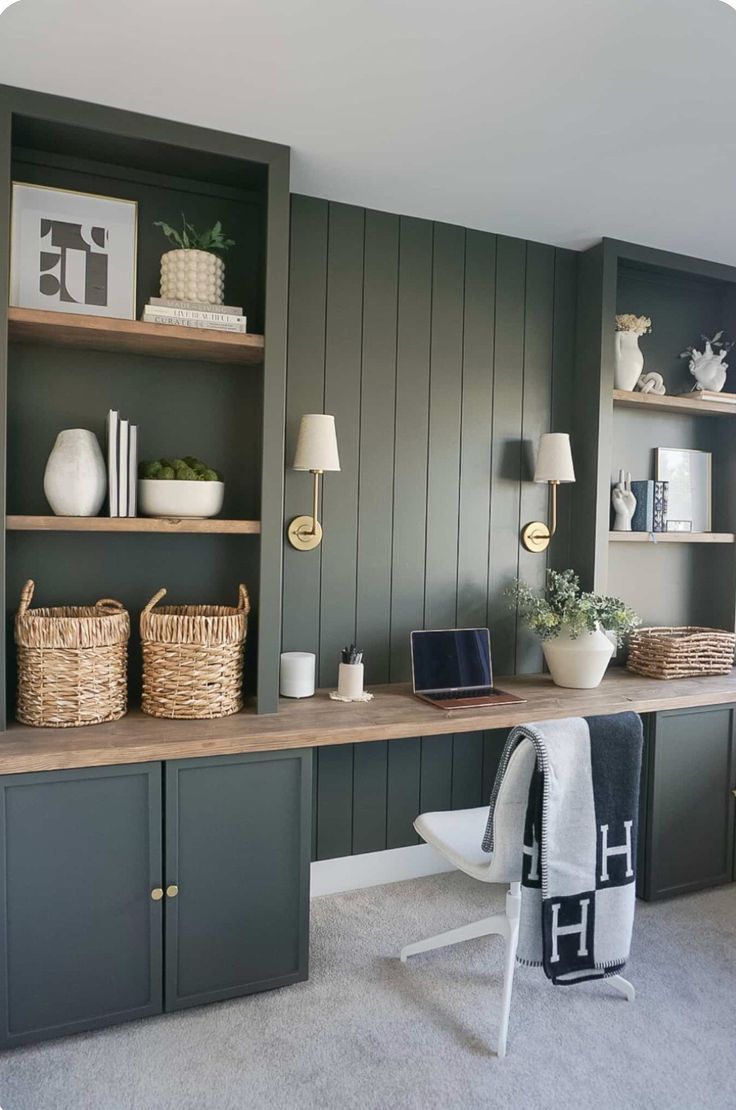 an office with green painted walls and open shelvings on the wall, along with wicker baskets