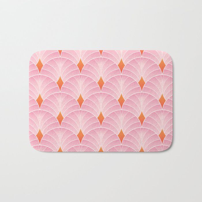 a pink and orange bath mat with an abstract design on the front, featuring wavy fan shapes