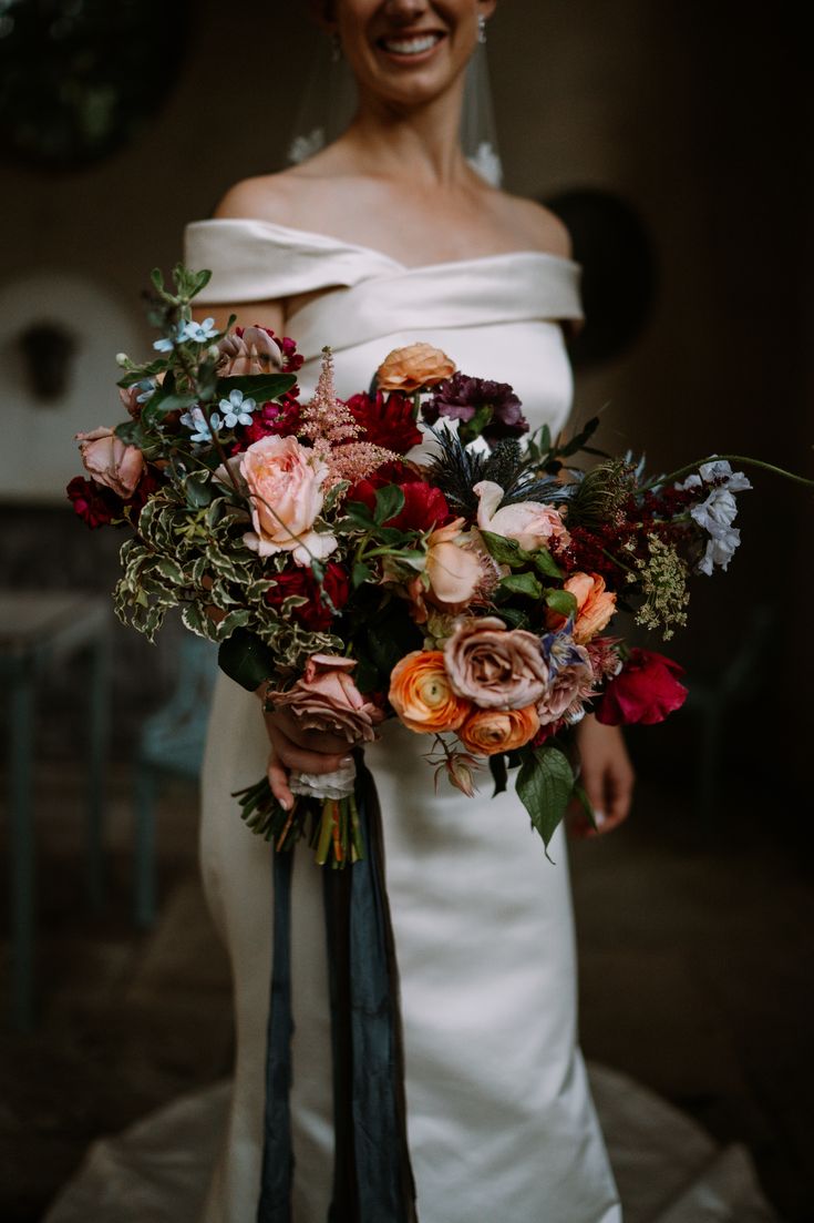 a woman holding a bouquet of flowers in her hands