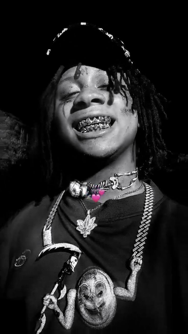 a young man with dreadlocks wearing a black t - shirt and silver necklace