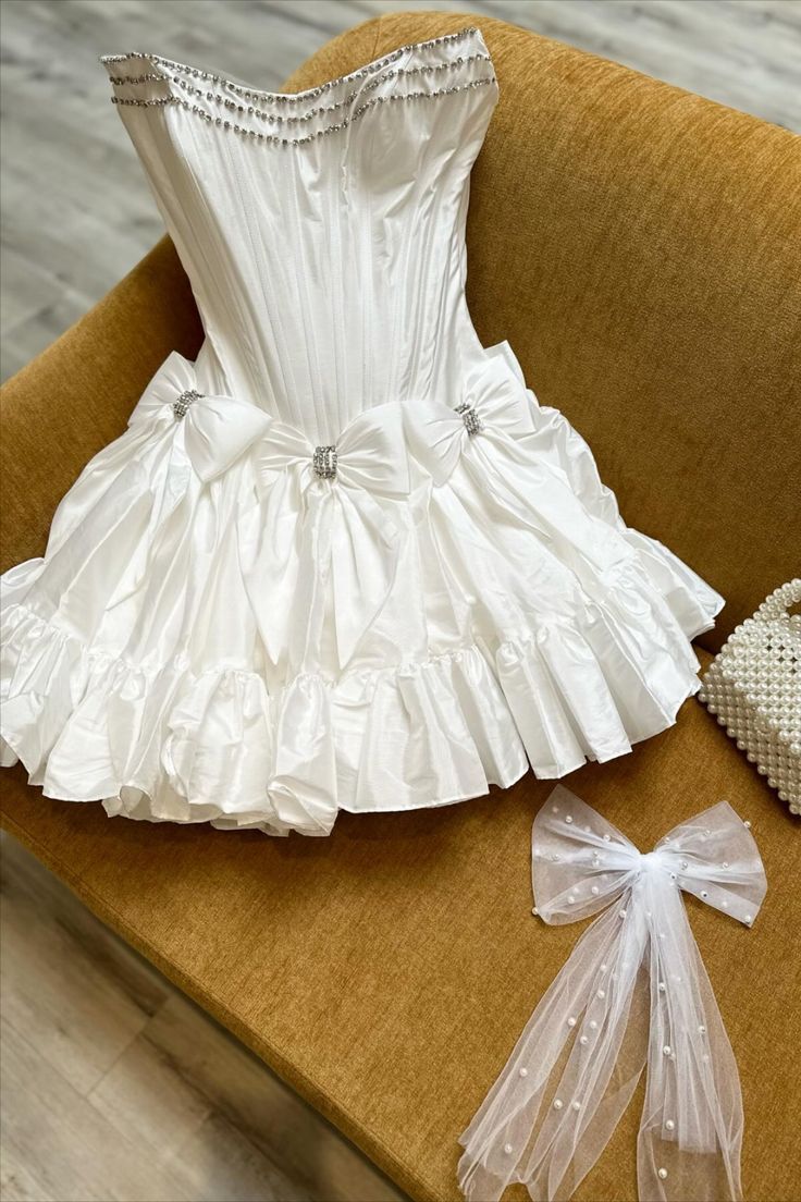 beaded strapless white taffeta A-line short princess dress with bows #homecomingdress #homecoming2024 #hocodress #winterformal2025 #graduationdress #partydress #winterformaldress #fallball #balldress #highschoolball #juniorpromdress #pageantdress #cocktaildress #minidress #partydress #sweet16dress #birthdaydress White Homecoming Dresses, Prom Accessories, Taffeta Fabric, Blue Homecoming Dresses, Satin Short, A Line Shorts, Short Homecoming Dress, Short Cocktail Dress, Black Prom Dresses