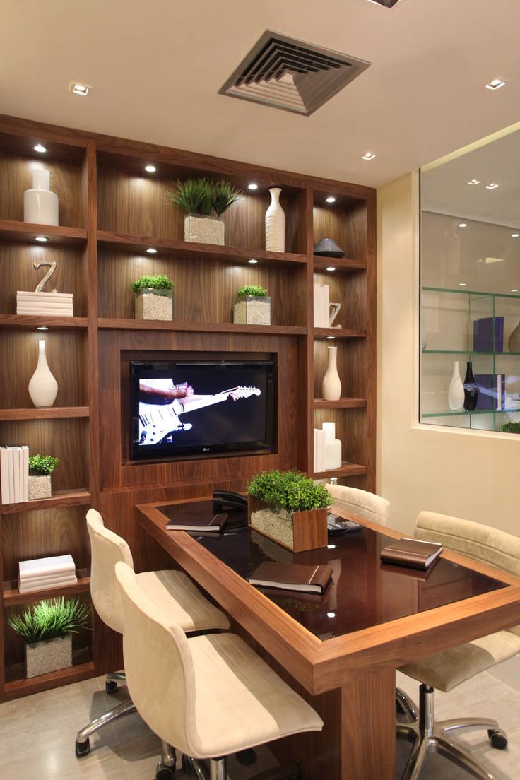 a large wooden table sitting in front of a tv mounted on a book case wall