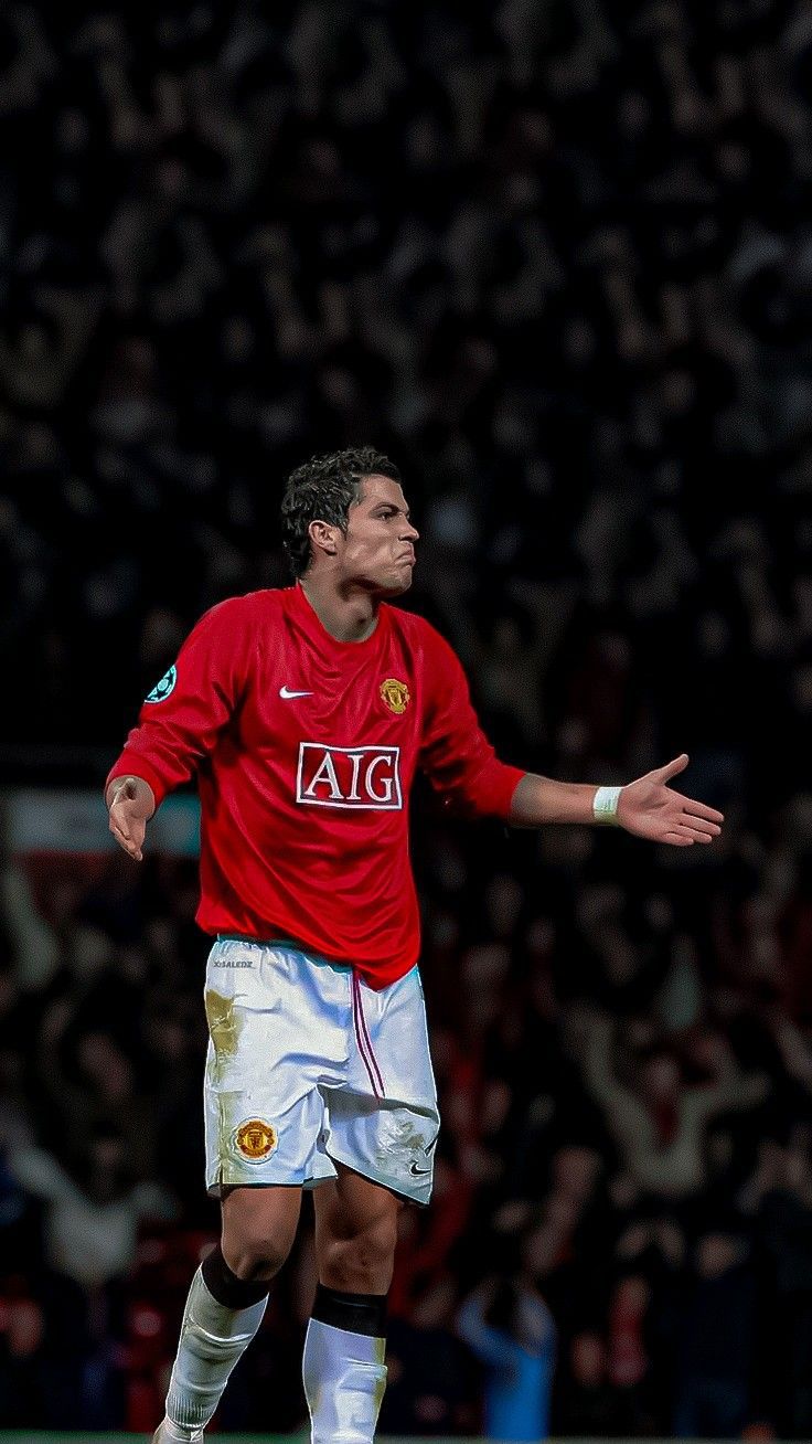 a man in red shirt kicking a soccer ball with his arms out and hands outstretched