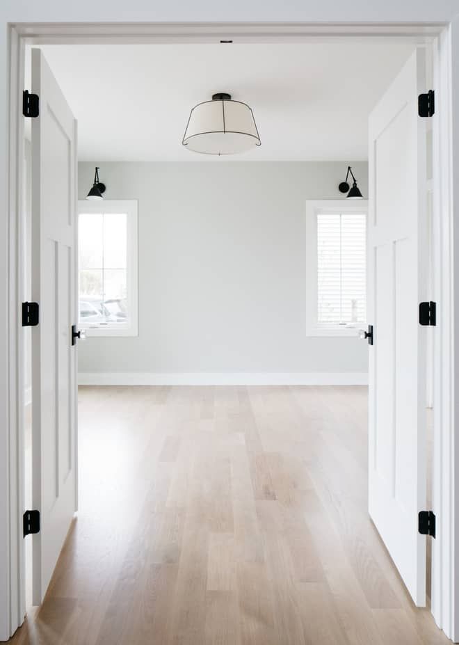 an empty room with white walls and hard wood flooring is seen from the doorway