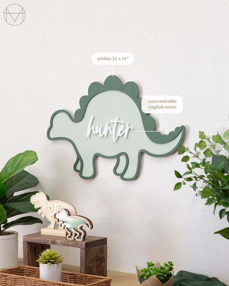 a dinosaur shaped wooden sign on a wall next to potted plants