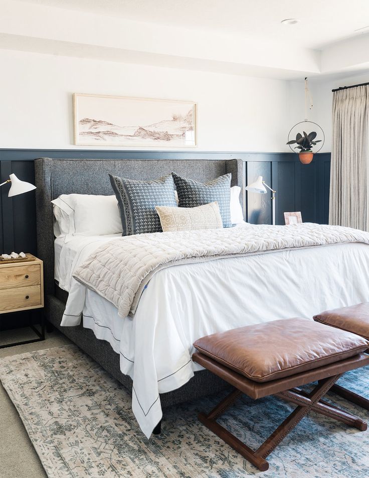 a bedroom with a large bed and two stools