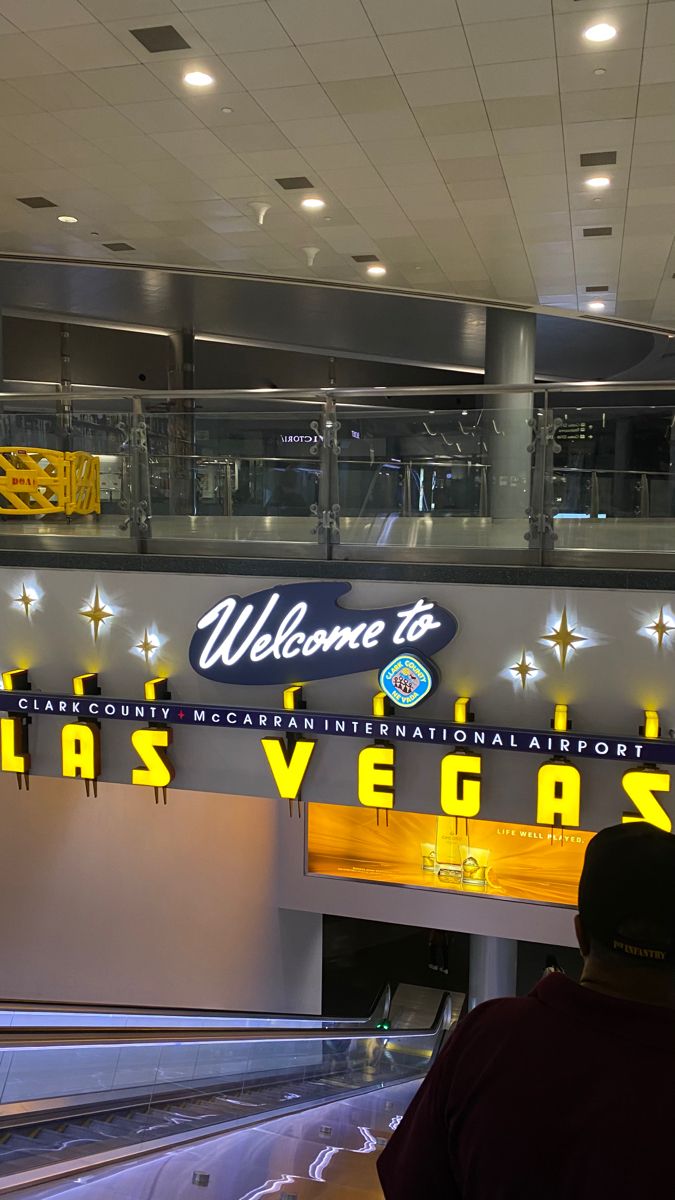 a man is standing in front of the las vegas sign