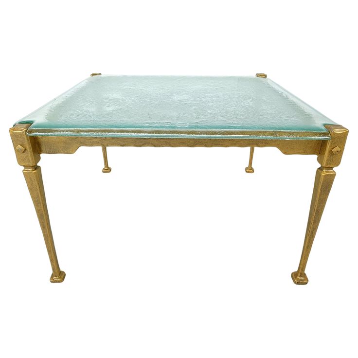 a glass and brass coffee table with two legs