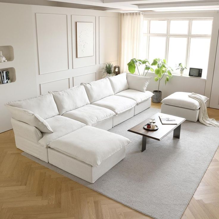 a large white couch sitting in a living room on top of a hard wood floor