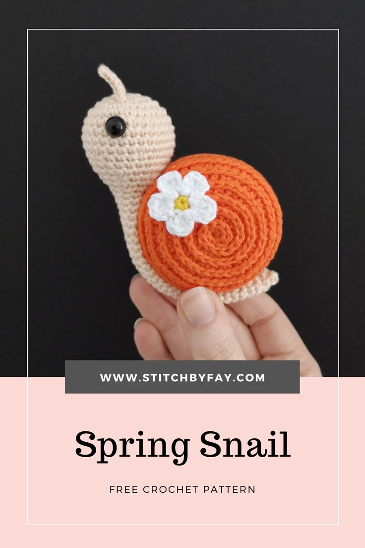 a small crocheted snail with a flower on it's head and the words spring