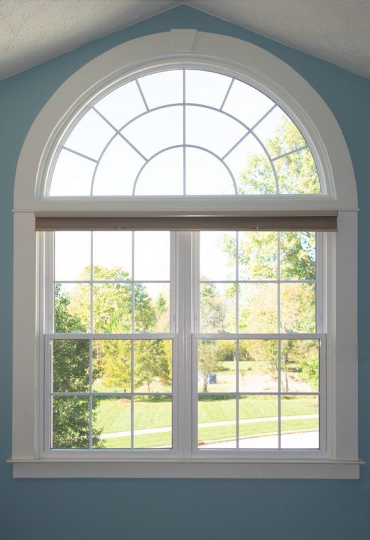 an arched window in a blue room with white trim