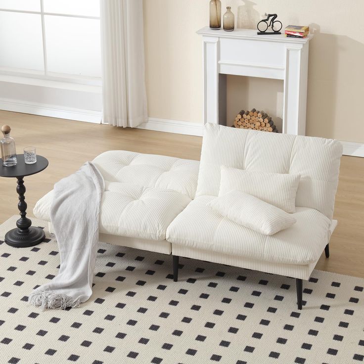 a white futon sofa sitting on top of a black and white checkered rug