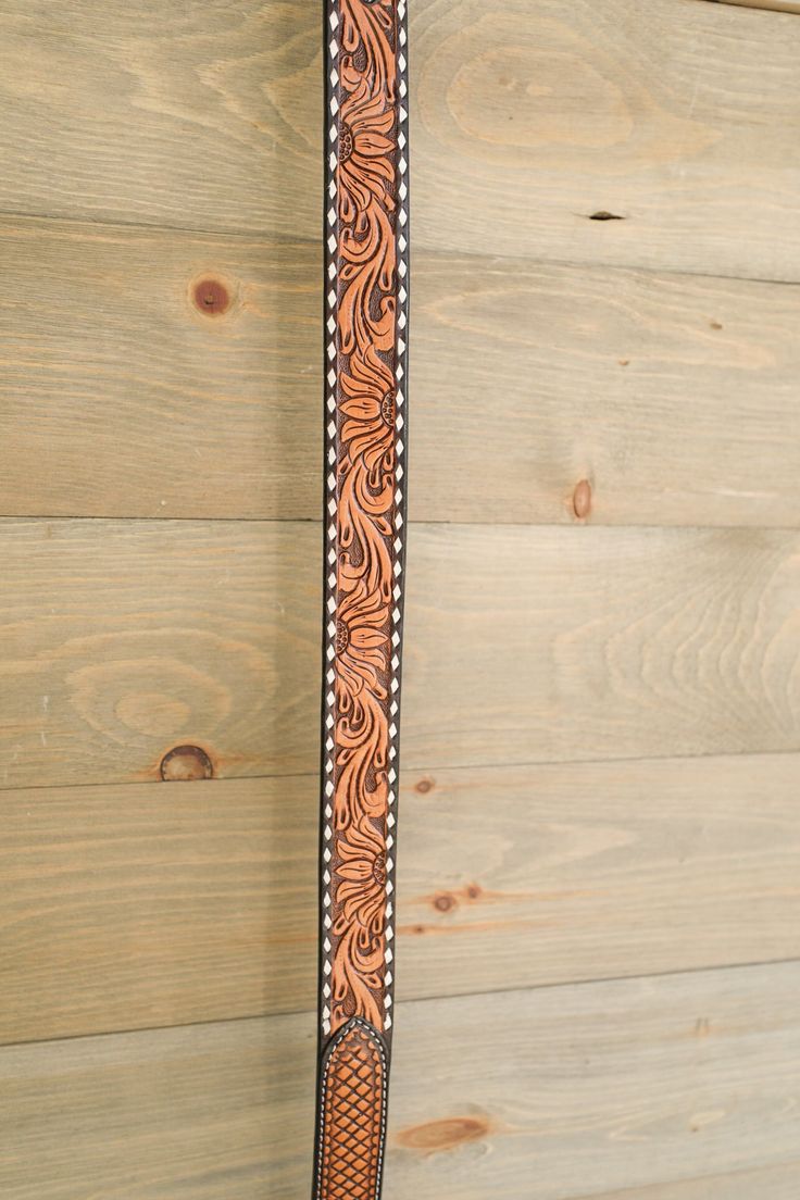 a brown and black belt hanging on a wooden wall