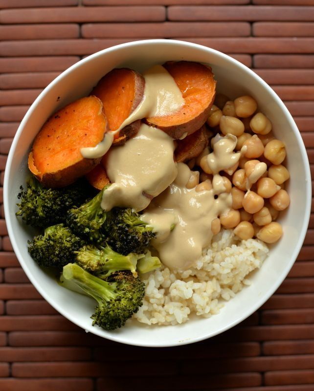 a white bowl filled with rice, broccoli and sweet potatoes