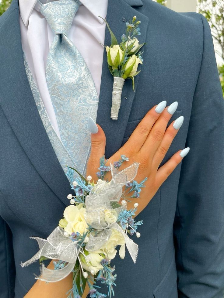 a close up of a person wearing a suit and tie with flowers on his lapel