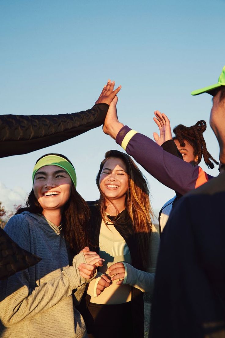 a group of people standing next to each other with their hands up in the air