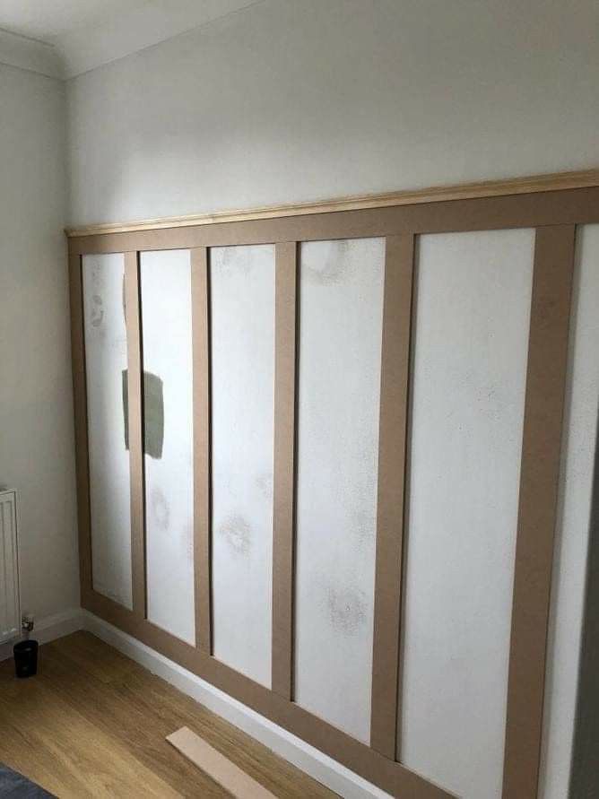 an empty room with white walls and wood trimmings on the wall, in front of a radiator