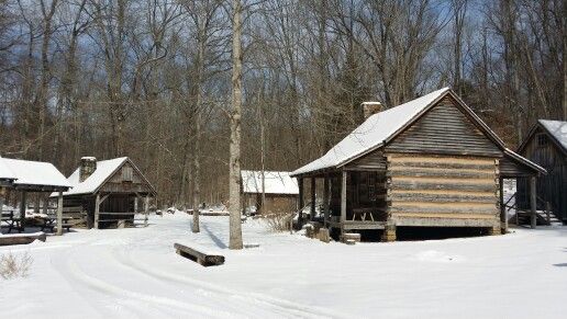 an old log cabin sits in the snow