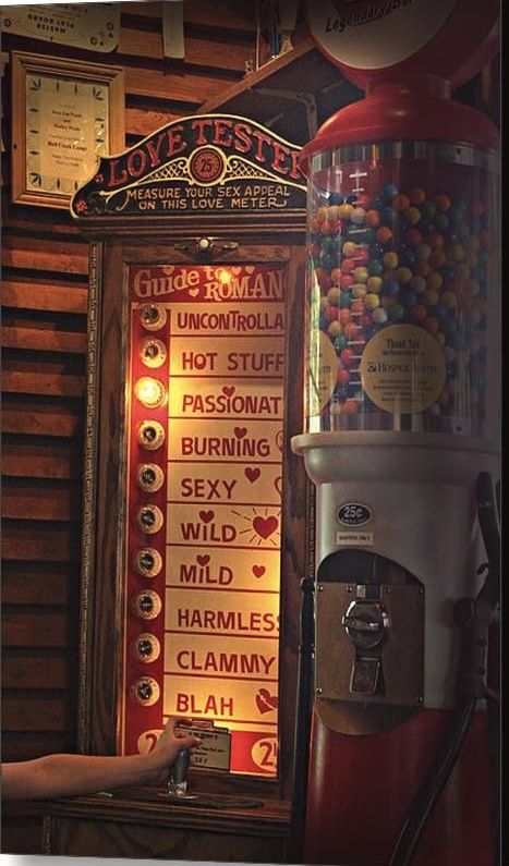 an old fashioned gummy machine in front of a sign