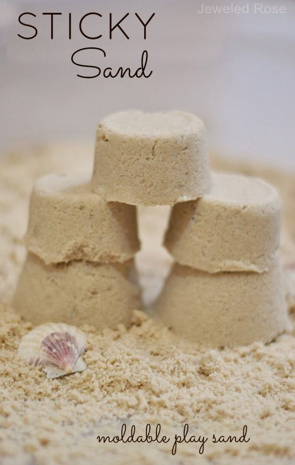 sand castle made out of small rocks and seashells with the words sticky sand written on it