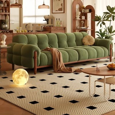 a living room with green couches and black and white rugs on the floor