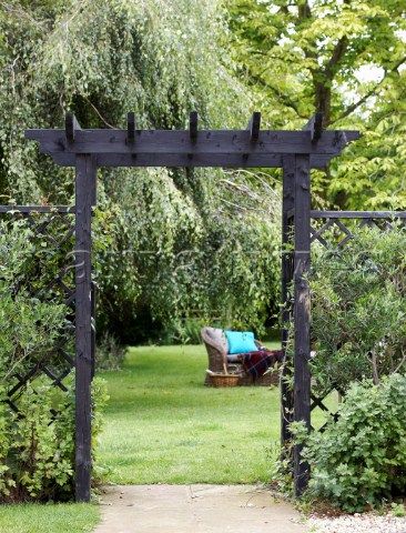 a wooden arbor in the middle of a garden