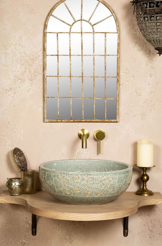 a bathroom sink sitting on top of a wooden table