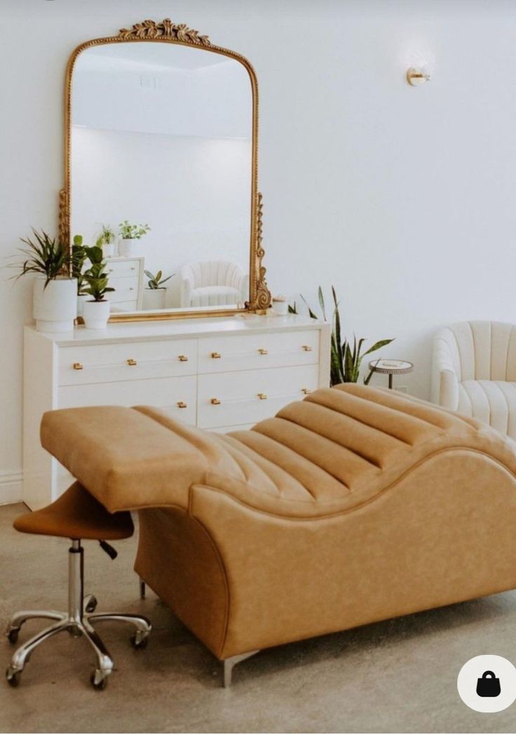 a living room with a couch, chair and mirror on the wall next to it