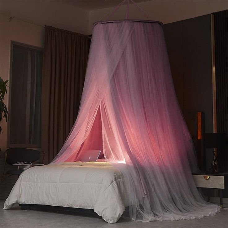 a bed that has a pink canopy over it