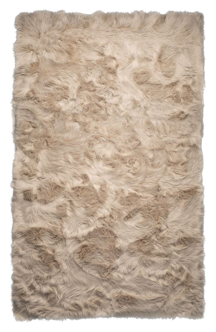 an area rug made out of sheepskin with white fur on the top and bottom