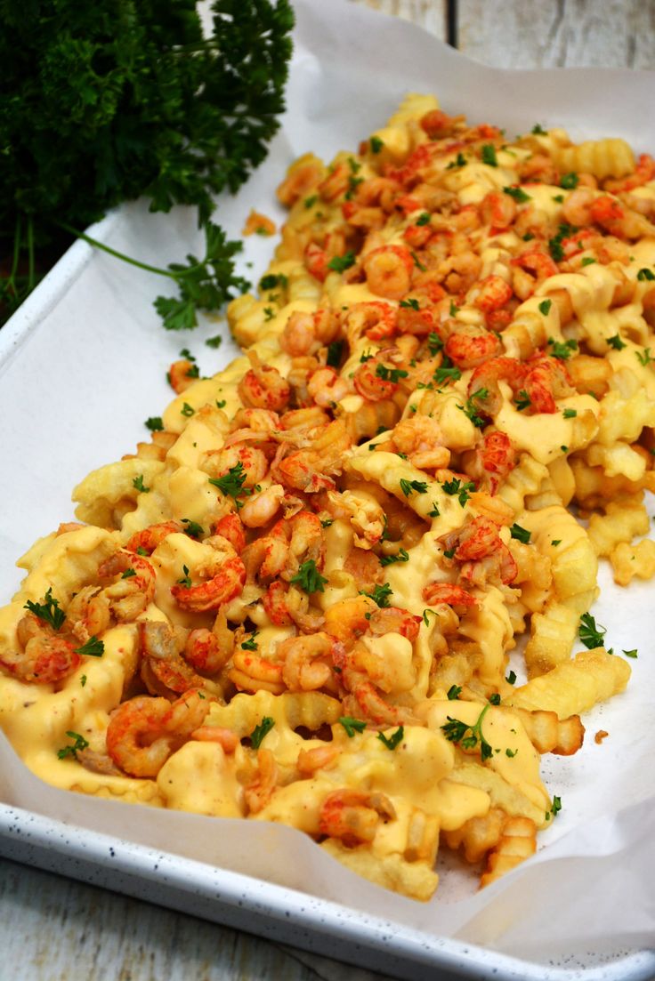 a tray filled with pasta covered in sauce and garnished with parsley