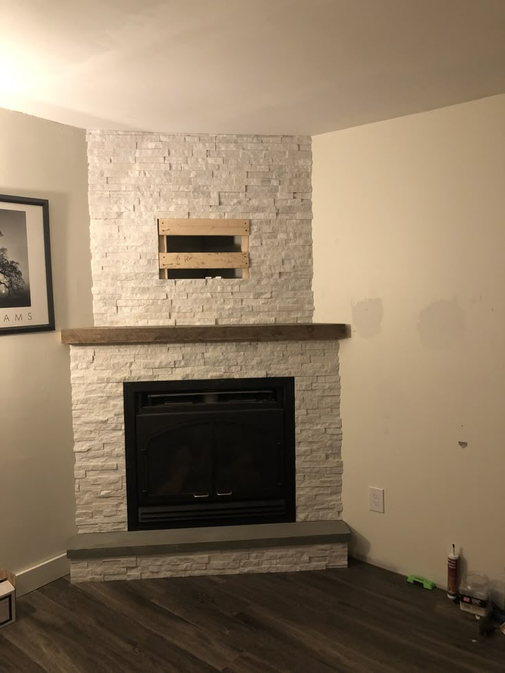 an empty living room with a fireplace and pictures on the wall