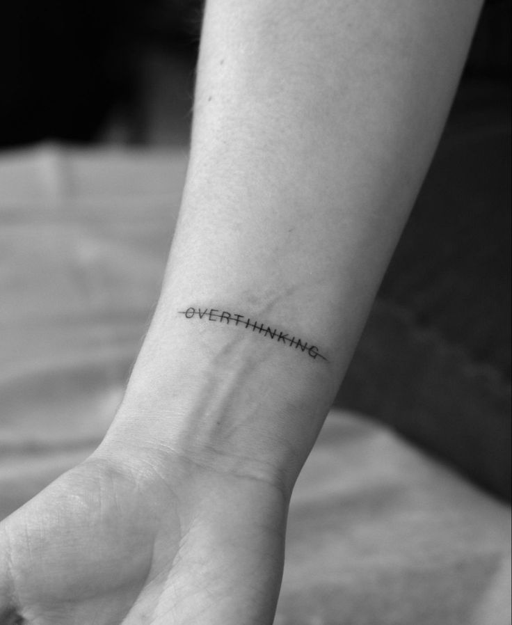 a woman's wrist with the words overfinishing written on her left arm