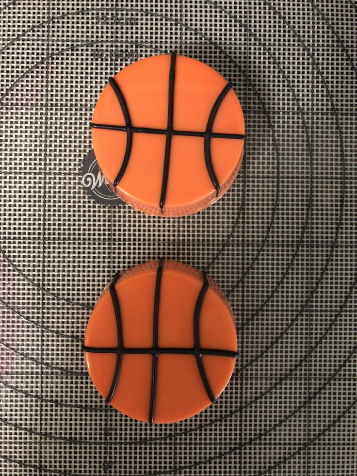 two cookies shaped like basketballs sitting on top of a table